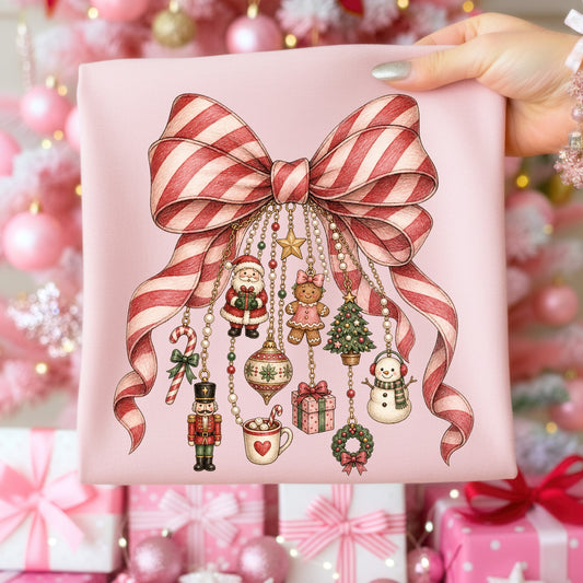 Pink fabric with candy cane striped bow and hanging Christmas ornaments.