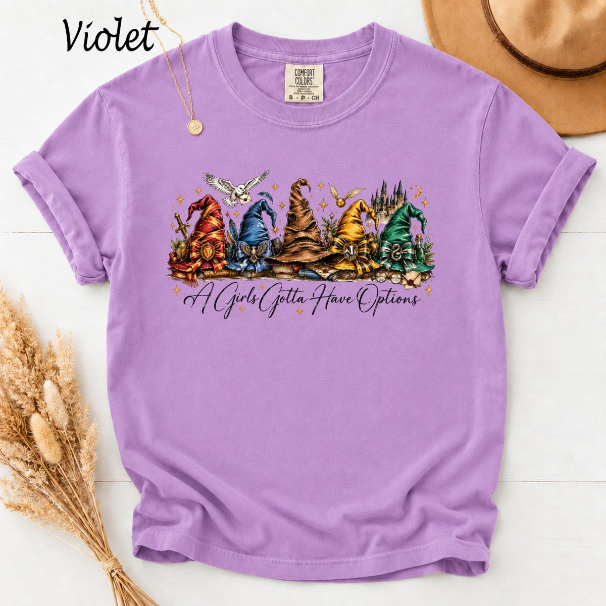 Purple t-shirt with Harry Potter-themed hats and owls, reads "A Girls Gotta Have Options".