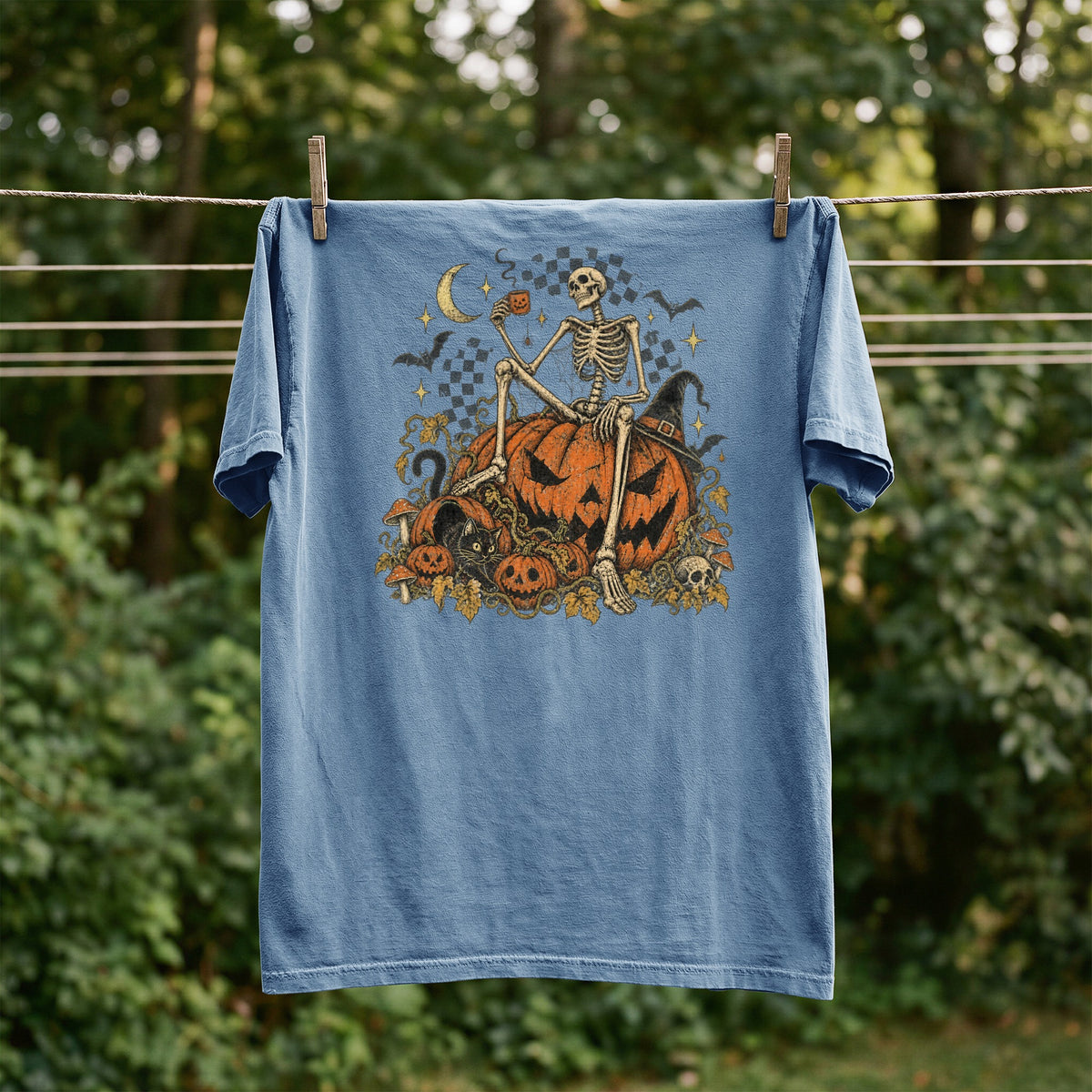 Blue t-shirt with Halloween skeleton, pumpkins, black cat, and moon graphic.