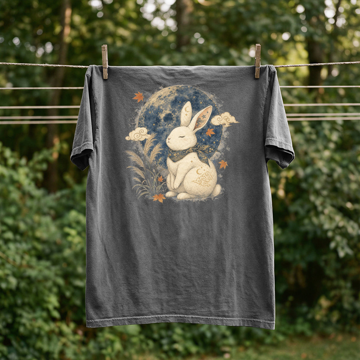 Dark grey t-shirt with a white rabbit design in front of a moon and clouds.