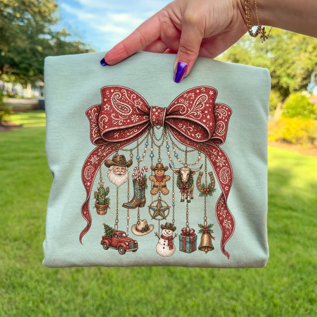 Light blue shirt with a red paisley bow and hanging Western-themed Christmas ornaments.