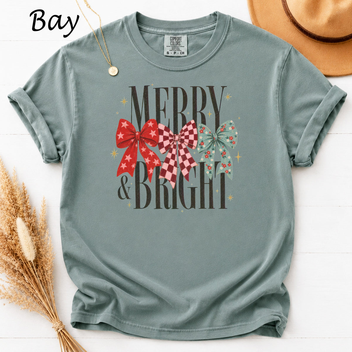Teal t-shirt with "Merry & Bright" text and three festive bows.