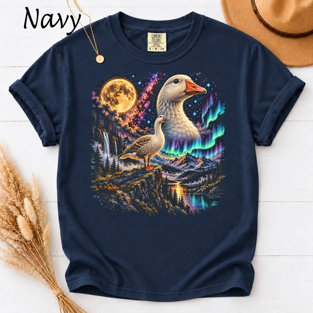 Navy t-shirt with a goose on a cliff under a full moon and aurora borealis.
