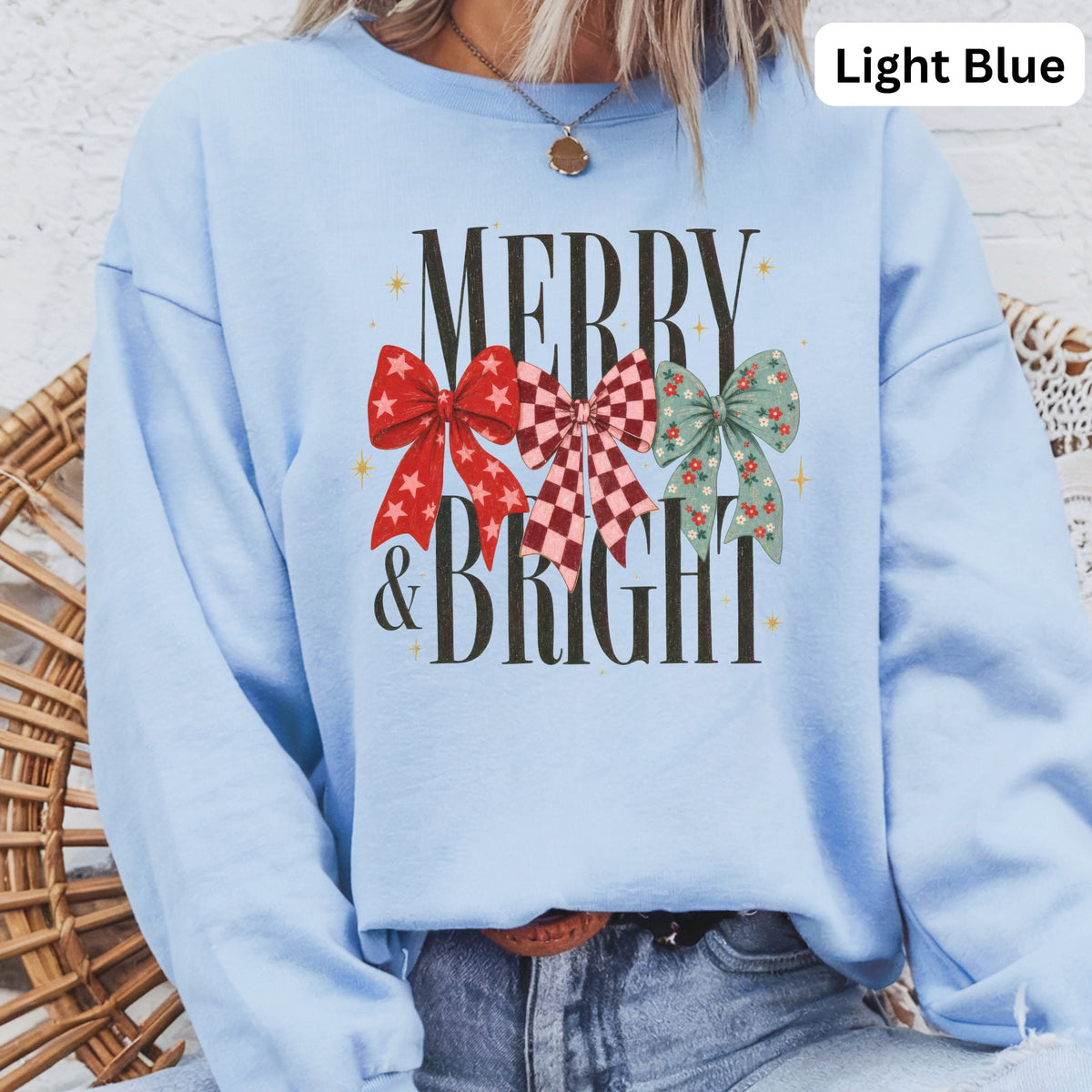 Light blue sweatshirt with "MERRY & BRIGHT" text and festive bow graphics.