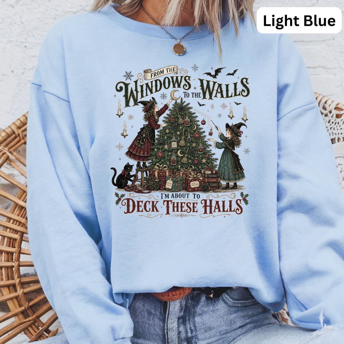 Light blue sweatshirt with witches decorating a tree, text "I'm About To Deck These Halls".