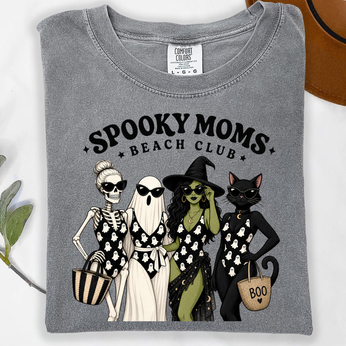 Gray t-shirt with "Spooky Moms Beach Club" and cartoon skeleton, ghost, witch, and cat.