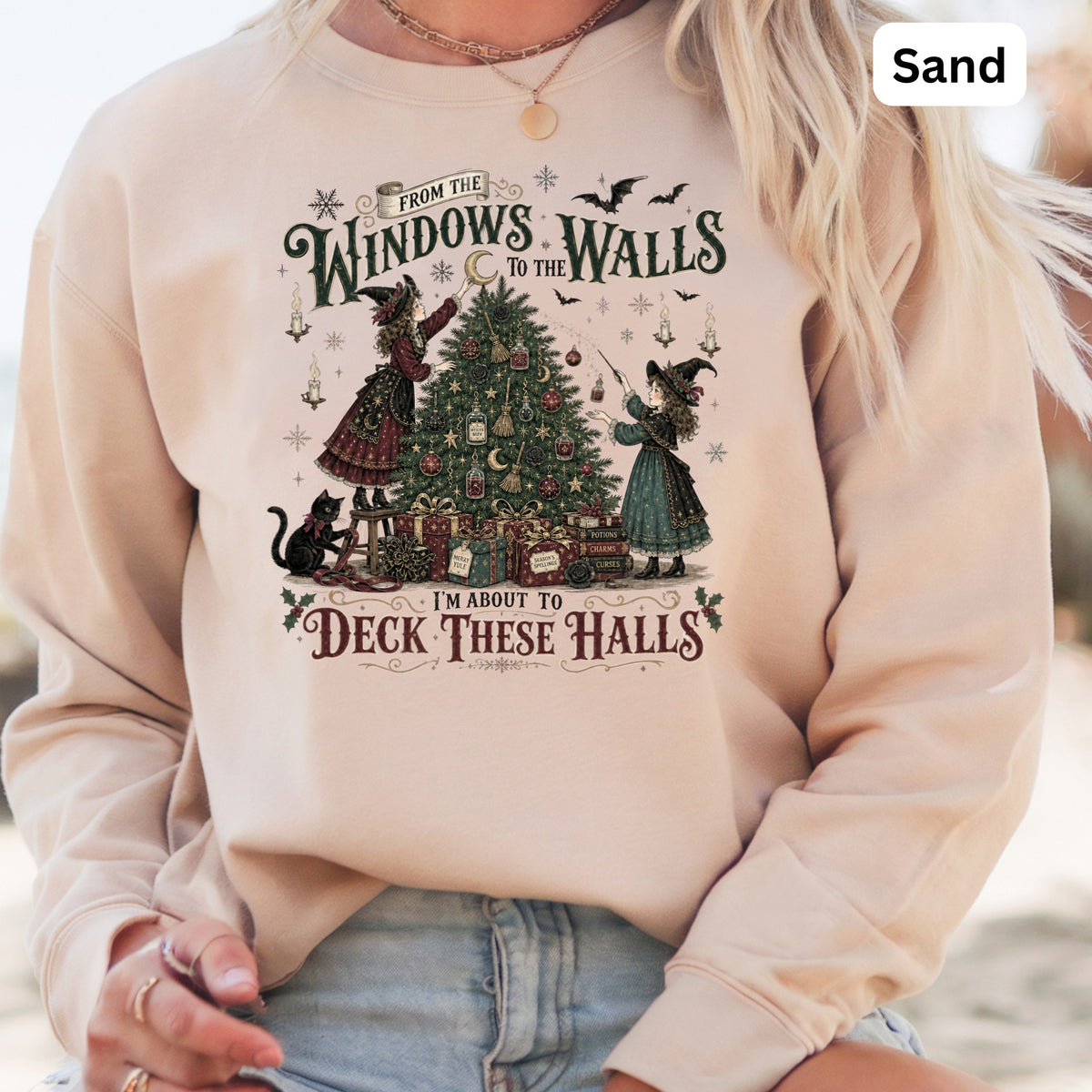 Sand sweatshirt with witches decorating a Christmas tree, "From the Windows to the Walls" text.