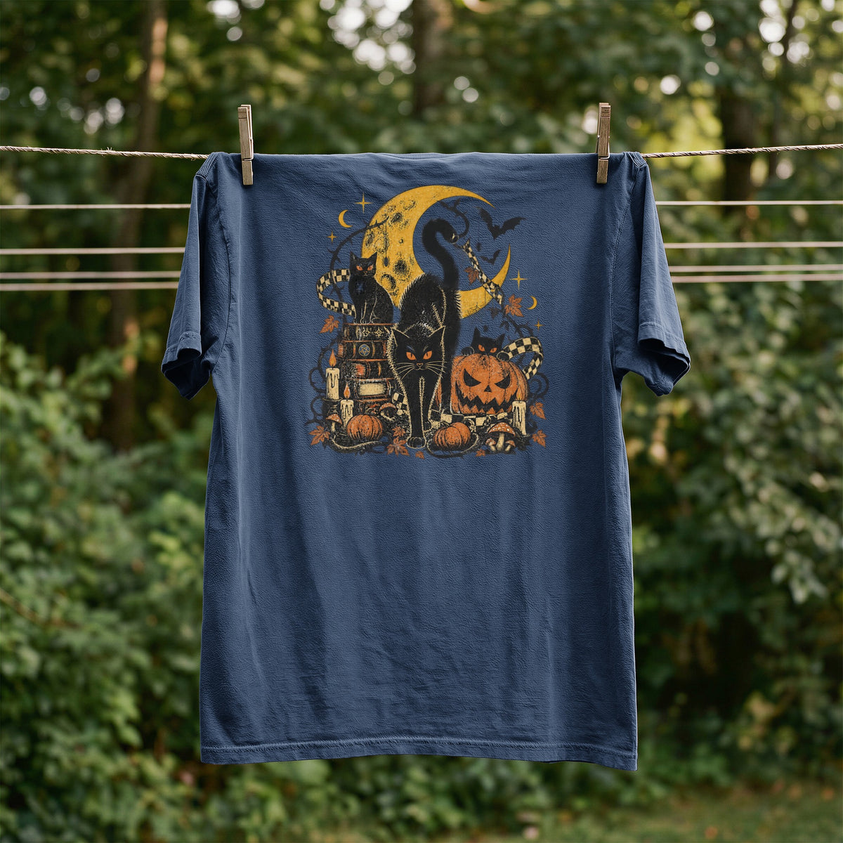 Navy t-shirt with Halloween graphic of black cats, pumpkins, moon, and candles.