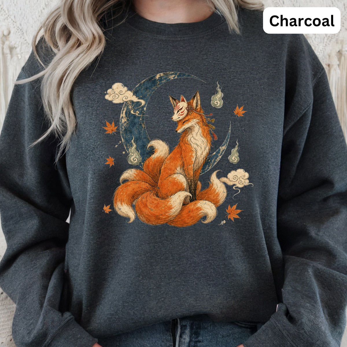 A nine-tailed fox with a mask sits on a crescent moon with clouds and leaves.