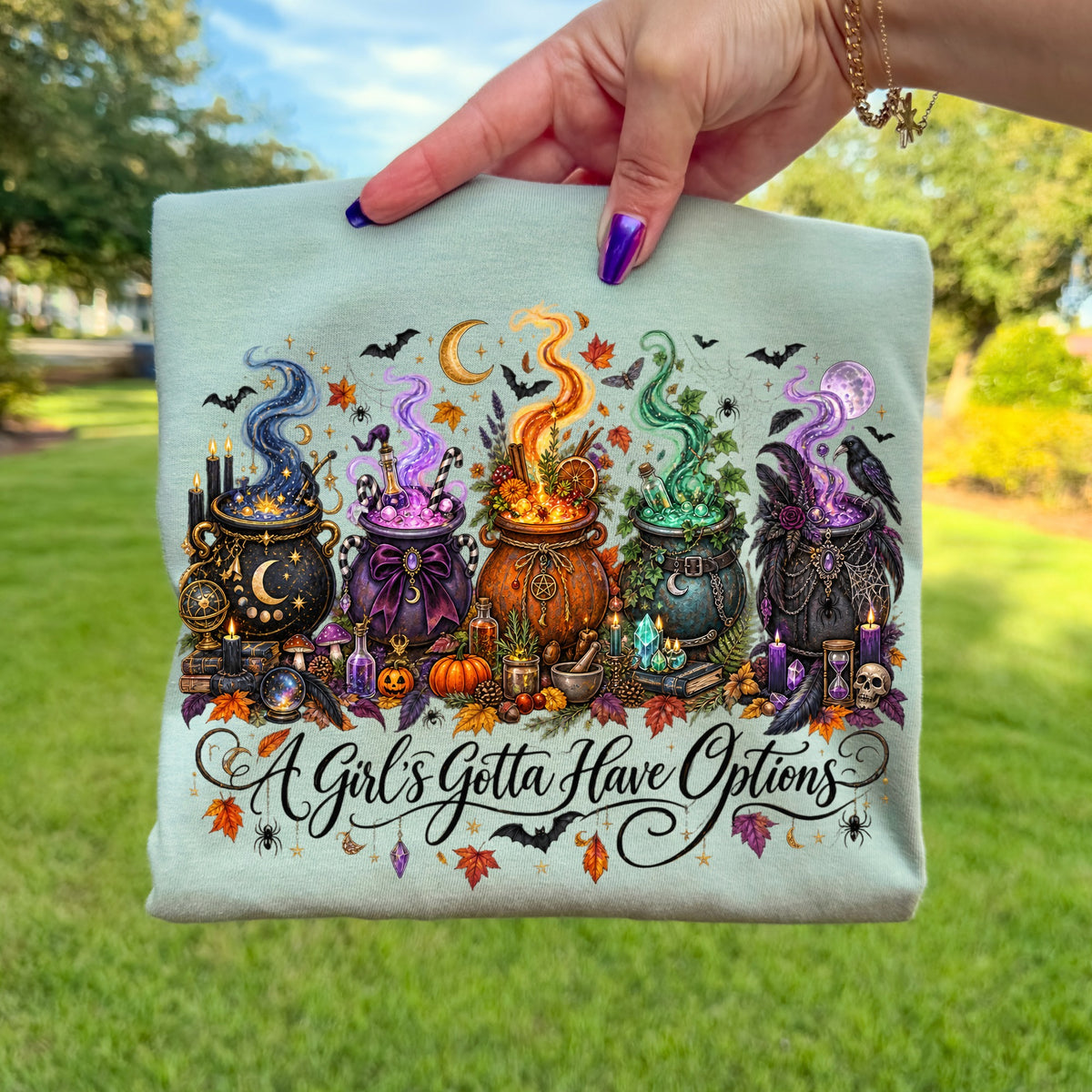 Halloween-themed graphic with five cauldrons, bats, moons, and the text "A Girl's Gotta Have Options."