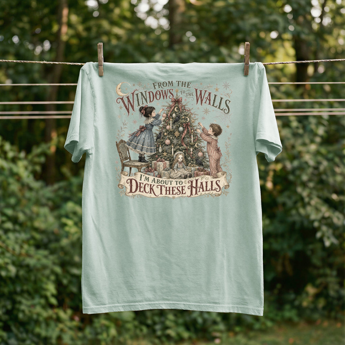 Light blue t-shirt with "From the Windows to the Walls, I'm About to Deck These Halls" text and Christmas scene.