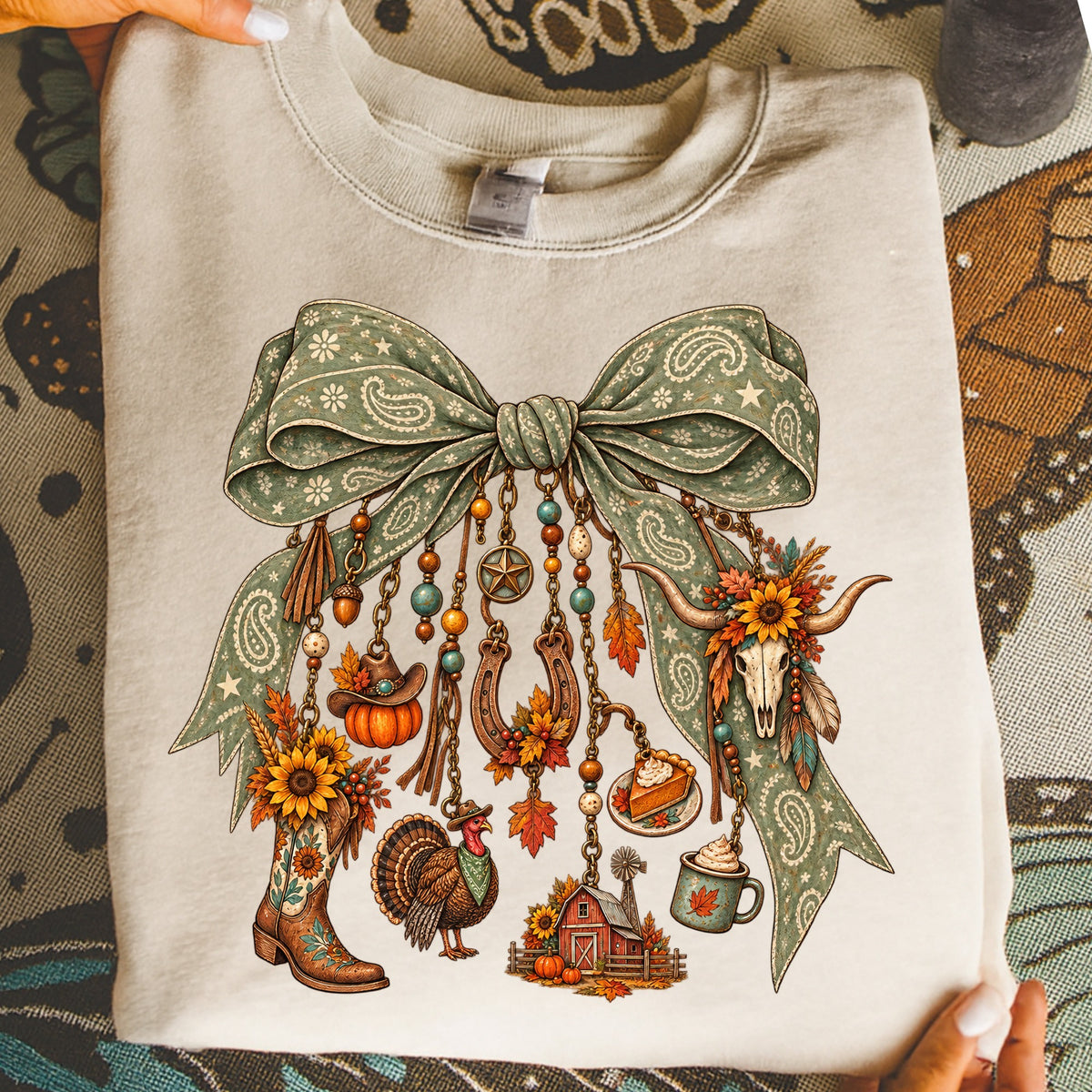 Cowboy boot, turkey, pumpkin, pie, and barn graphic on a light-colored sweatshirt.