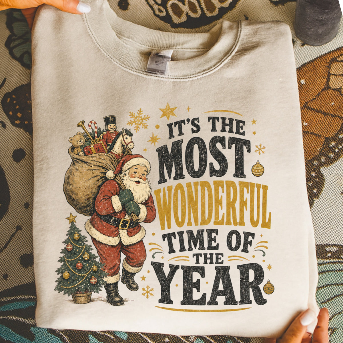 Cream sweatshirt with Santa, toys, Christmas tree, and text "It's the Most Wonderful Time of the Year."