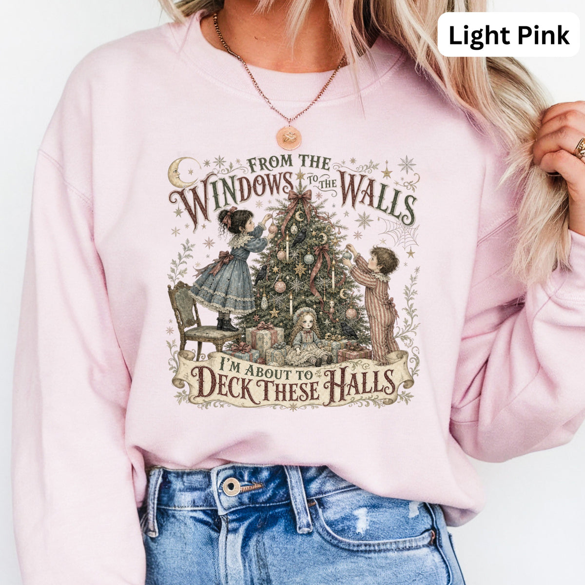 Light pink sweatshirt with graphic of children decorating a Christmas tree and text "I'm About to Deck These Halls".