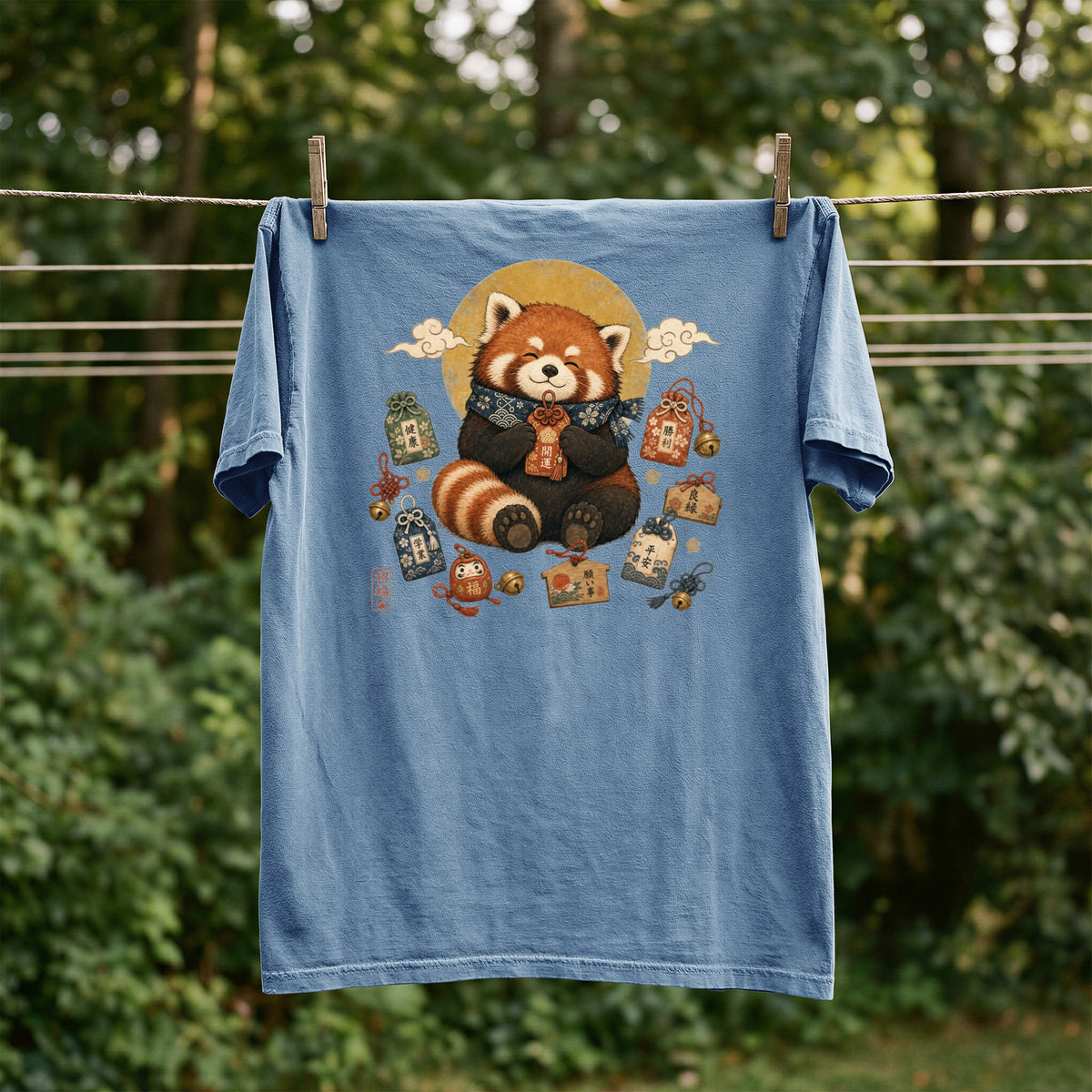 Blue t-shirt with a red panda illustration surrounded by Japanese amulets.