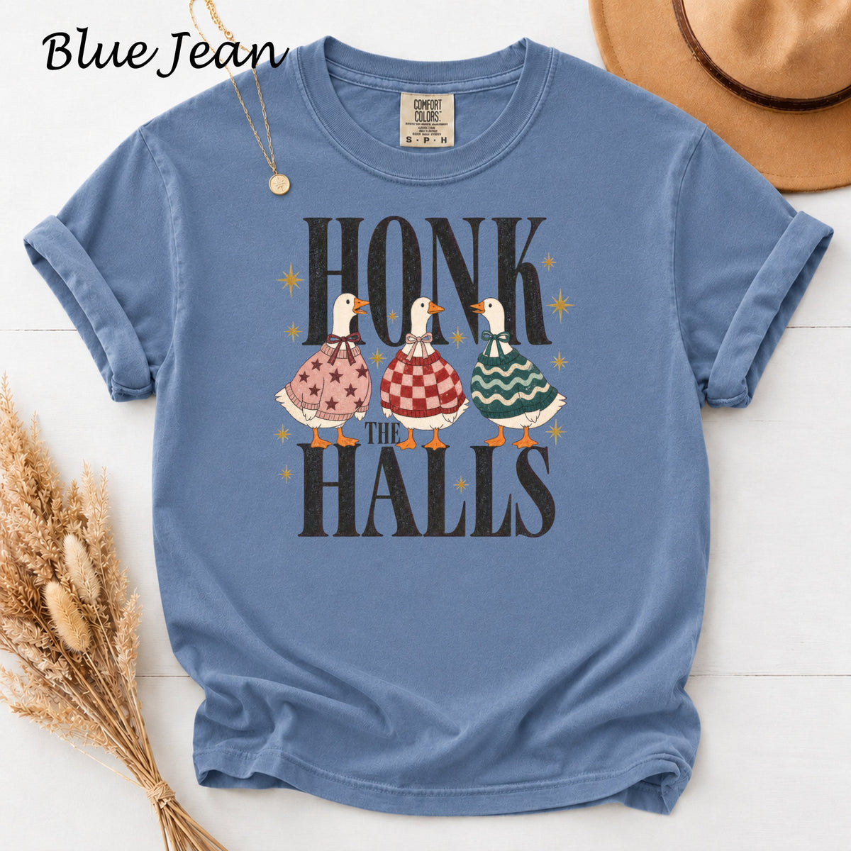 Blue t-shirt with three geese wearing sweaters and the text "Honk the Halls".