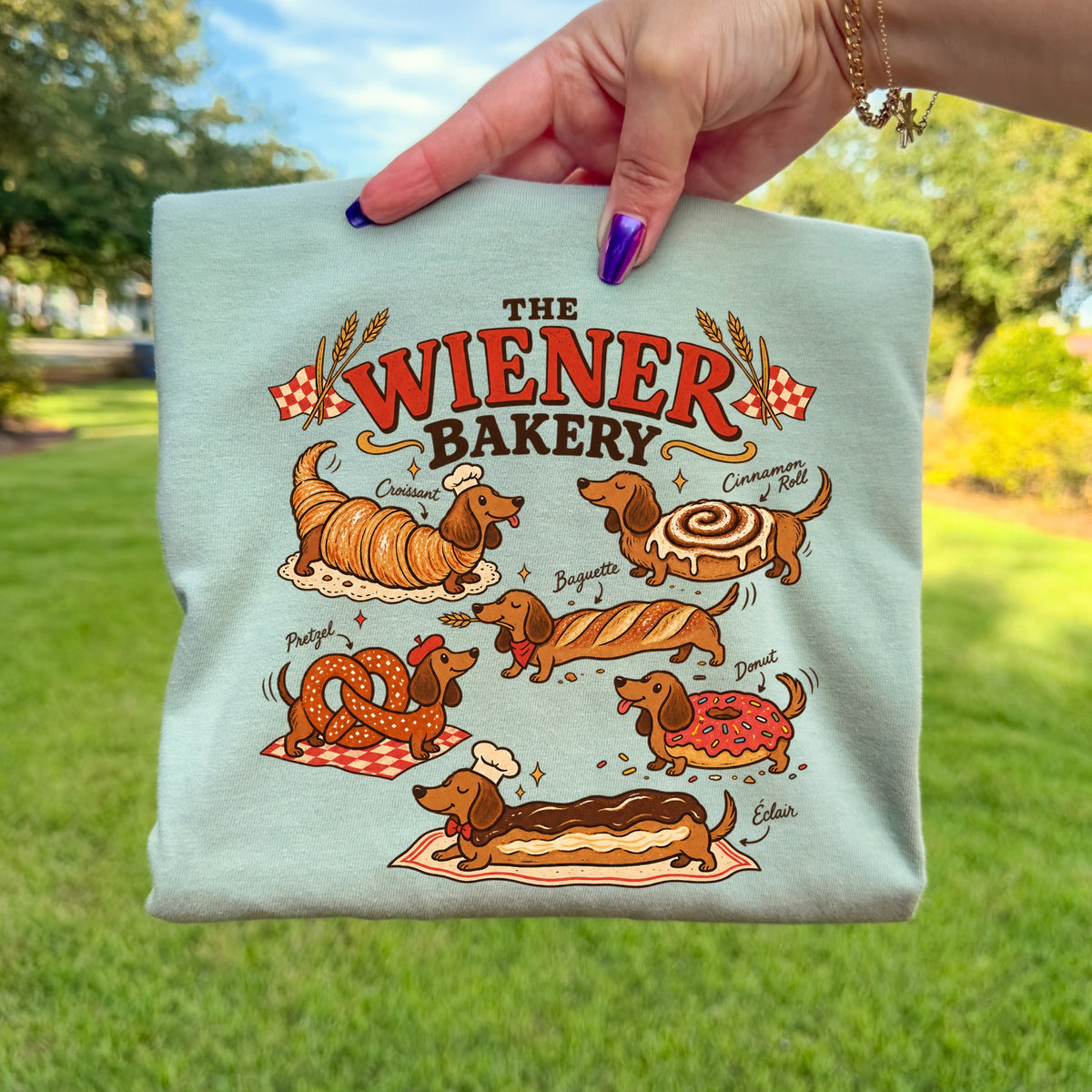 The Wiener Bakery graphic features dachshunds as various baked goods, including a croissant, cinnamon roll, and eclair.