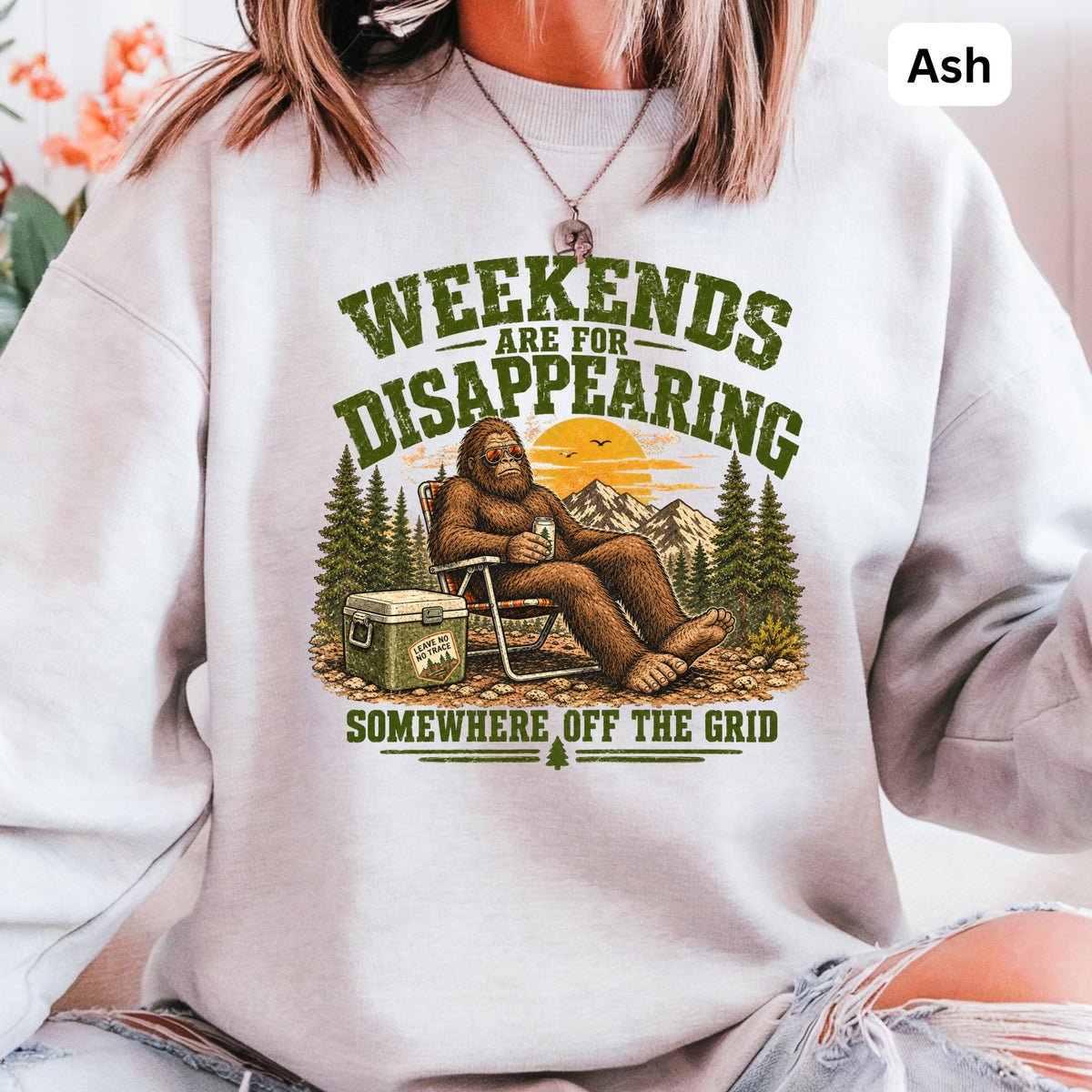 Bigfoot relaxing in a camping scene with text "Weekends are for disappearing somewhere off the grid."