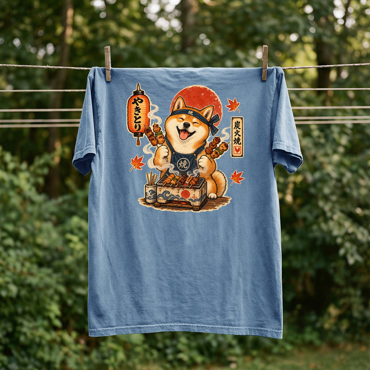 Blue t-shirt with illustration of a Shiba Inu grilling yakitori with Japanese text.