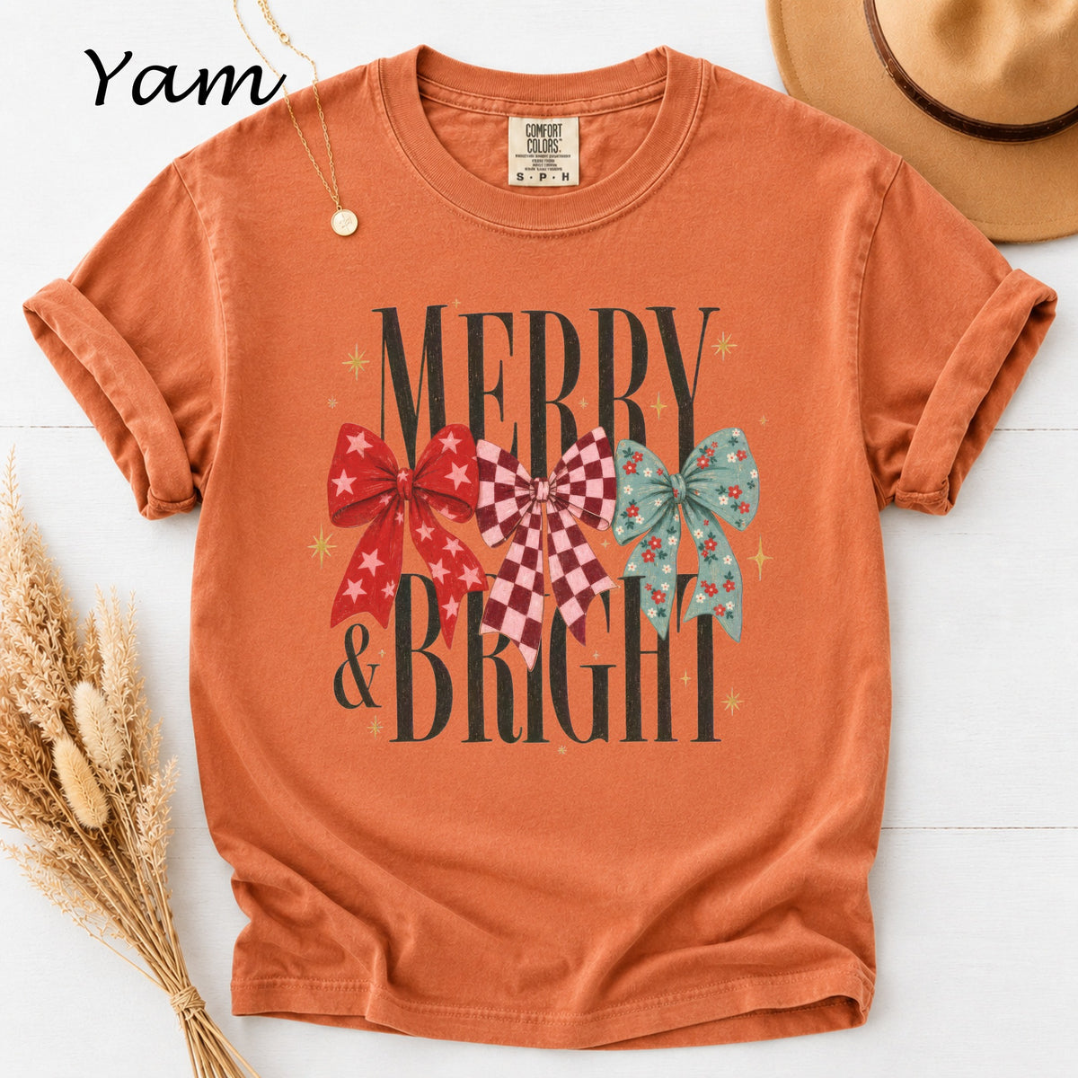 Orange t-shirt with "Merry & Bright" text and three decorative bows.