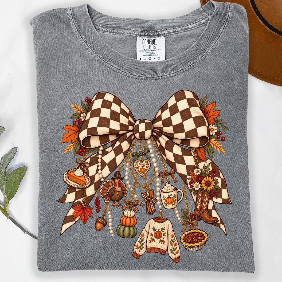 Gray t-shirt with a checkered bow and fall-themed charms including a turkey, pie, and pumpkin sweater.