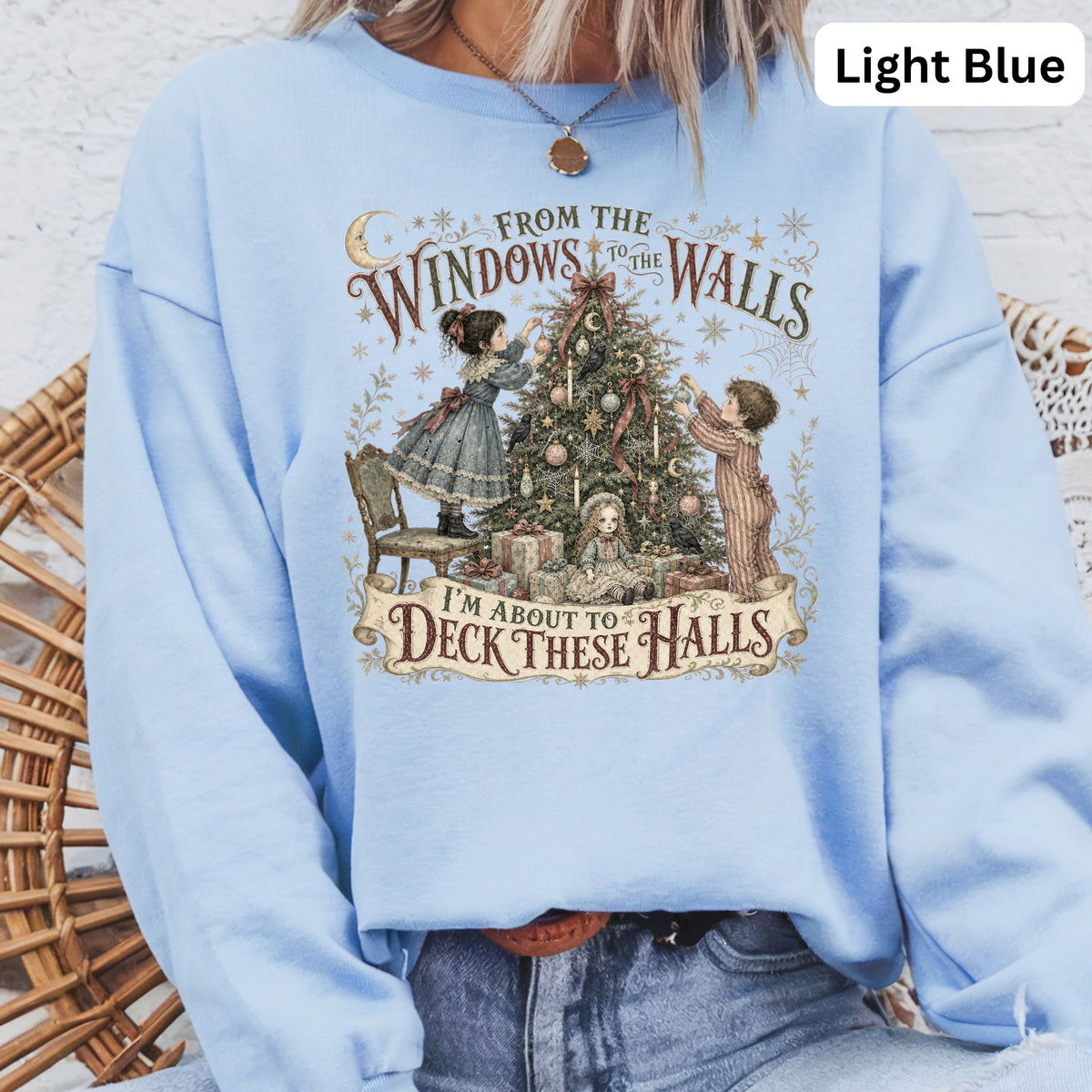 Light blue sweatshirt with holiday graphic of children decorating a Christmas tree and the text "I'm About to Deck These Halls".
