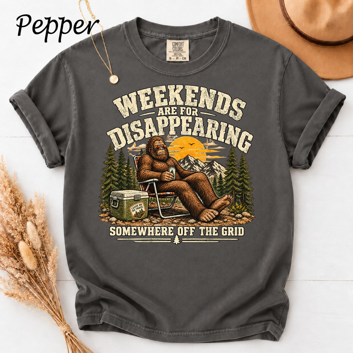 Bigfoot relaxing with a drink, text "Weekends Are For Disappearing Somewhere Off The Grid".