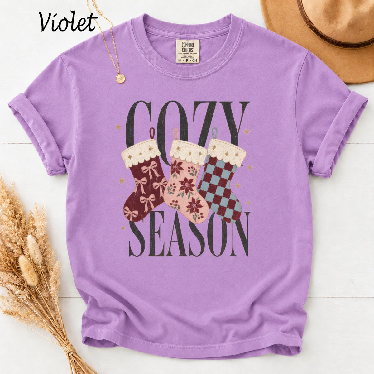 Purple t-shirt with "Cozy Season" text and three festive stockings.