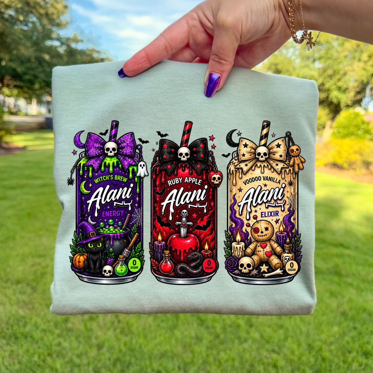 Three Halloween-themed Alani drink cans: Witch's Brew, Ruby Apple, and Voodoo Vanilla.