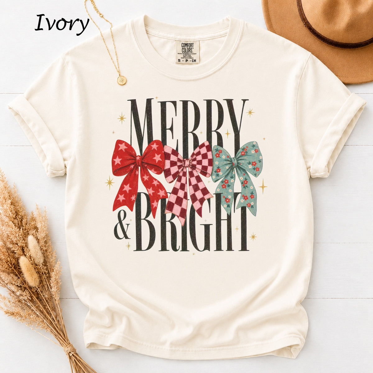 Ivory t-shirt with "MERRY & BRIGHT" text and three decorative bows.