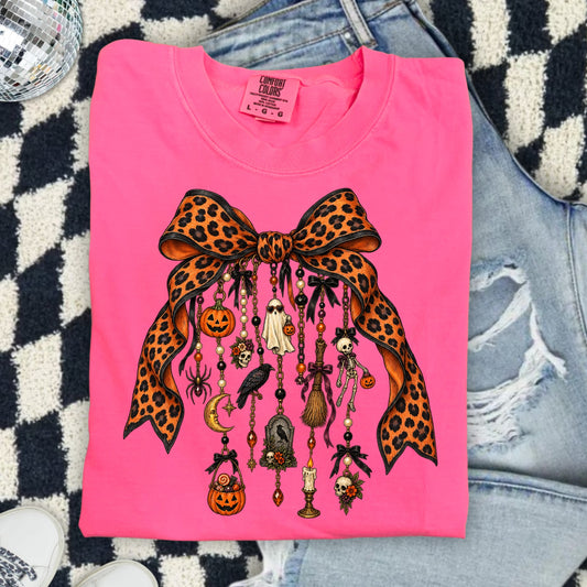 Pink Comfort Colors t-shirt with leopard print bow and Halloween charms.