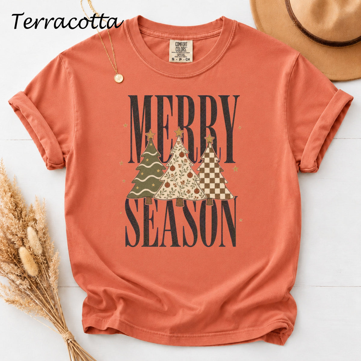 Terracotta t-shirt with "Merry Season" text and three decorative Christmas trees.