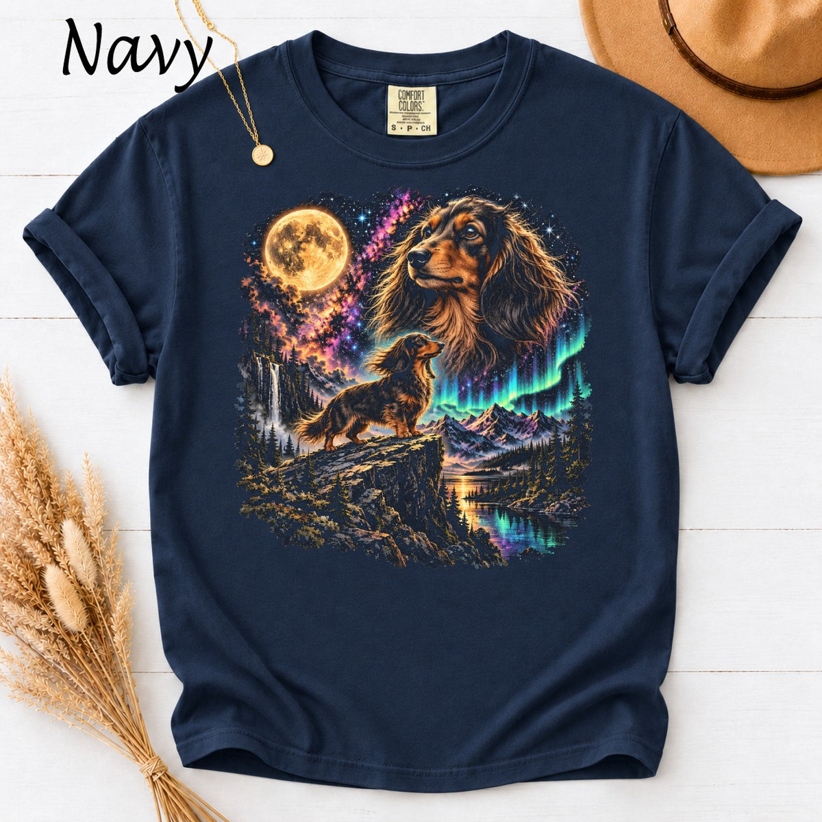 Navy t-shirt with graphic of two dachshunds, moon, waterfall, and aurora borealis.