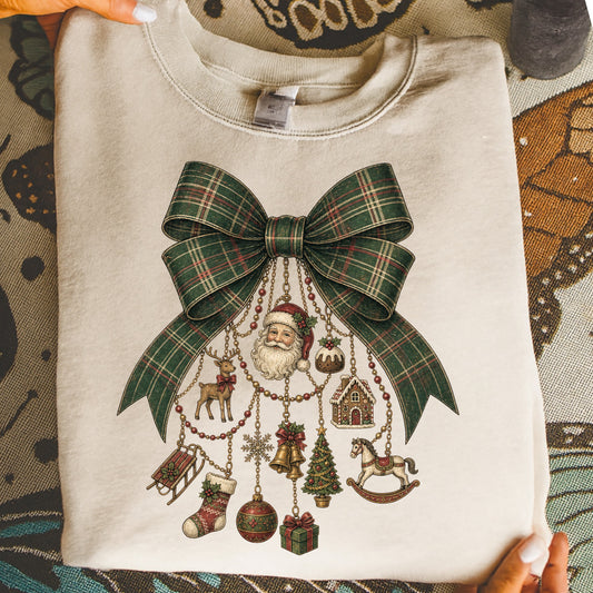 Cream sweatshirt with a plaid bow and hanging Christmas ornaments: Santa, reindeer, stocking, sled.