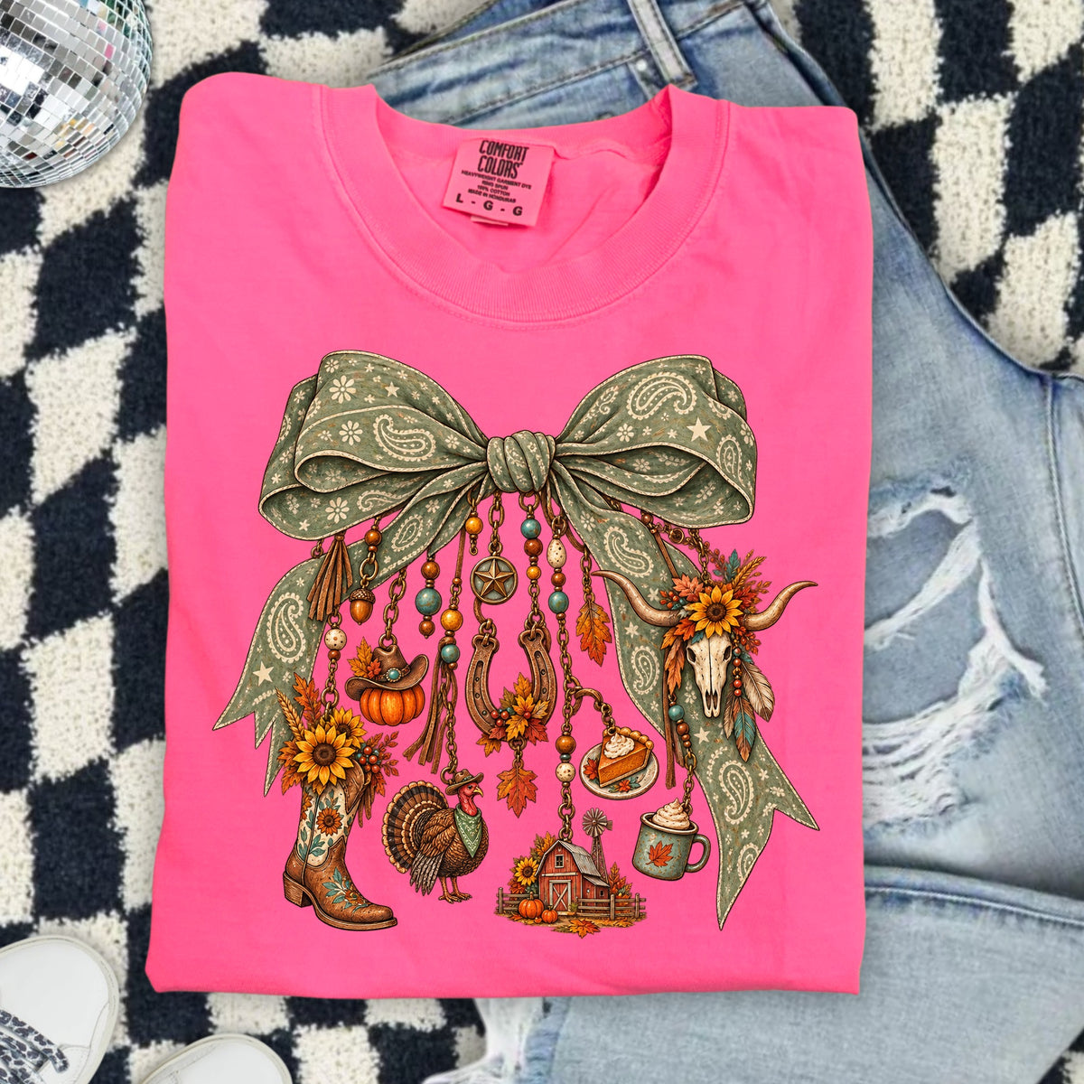 Pink t-shirt with a bow graphic featuring fall and western elements.
