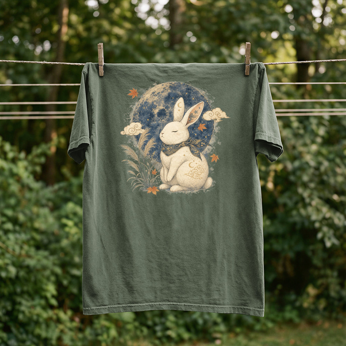 Green t-shirt with a white rabbit design under a starry moon.