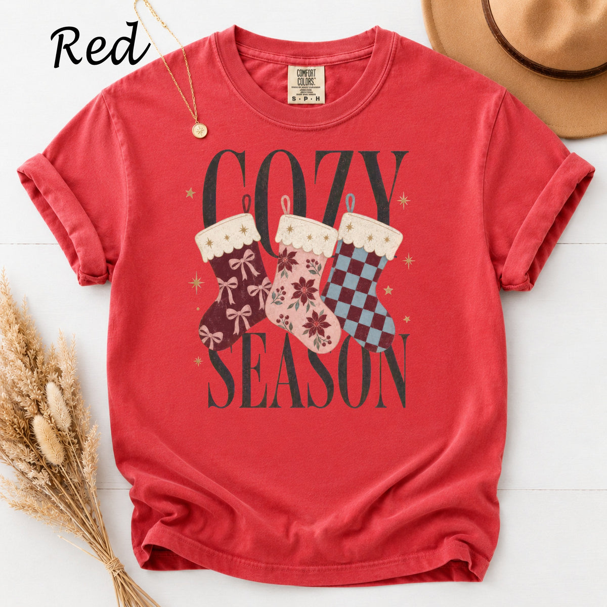 Red t-shirt with "Cozy Season" graphic featuring three Christmas stockings.