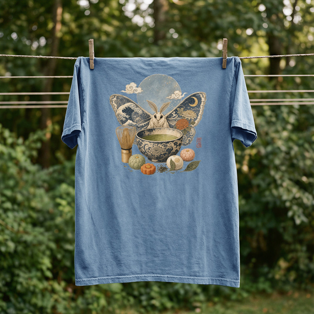 Blue t-shirt with moth, moon, matcha, and mooncakes graphic.
