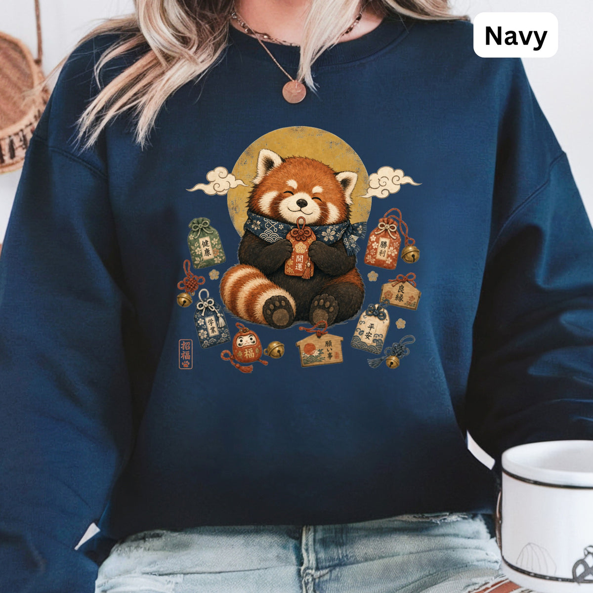 Navy sweatshirt with a red panda wearing a scarf surrounded by Japanese lucky charms.