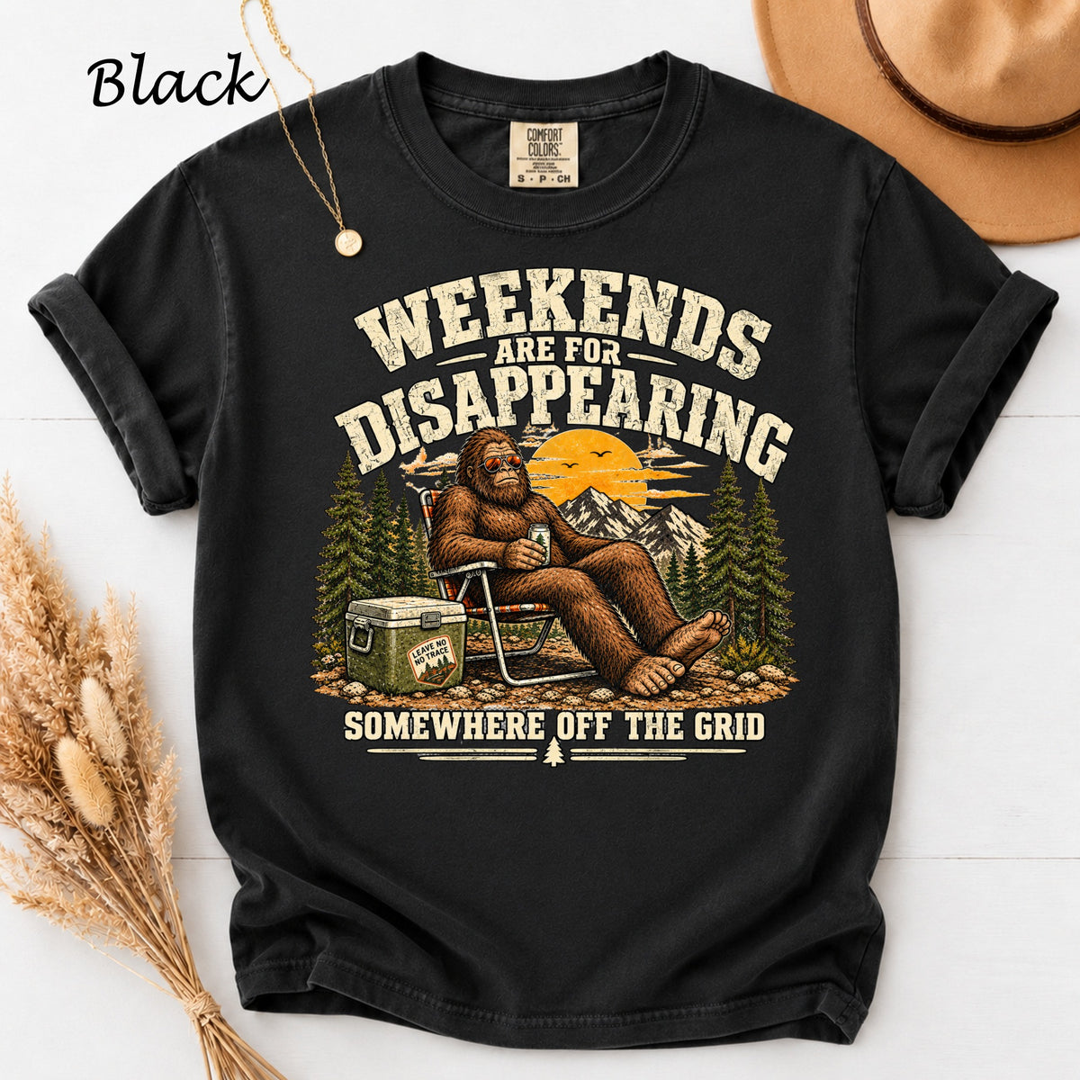 Black t-shirt with Bigfoot graphic reading "Weekends are for disappearing somewhere off the grid."
