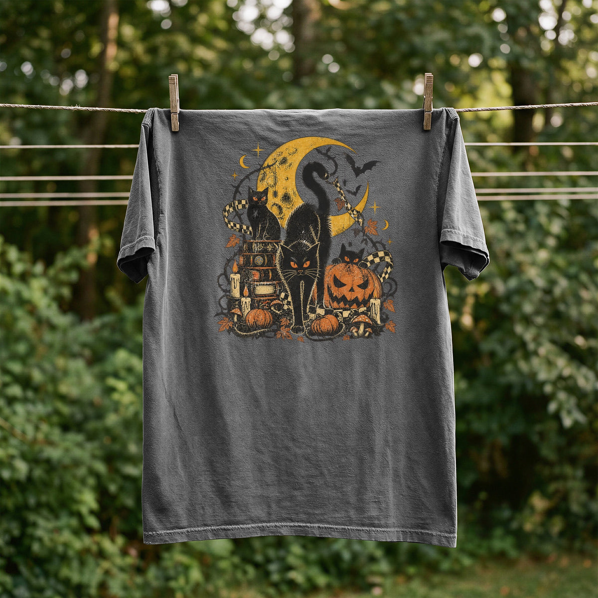 Dark grey t-shirt with Halloween graphic of black cats, moon, pumpkins, and candles.