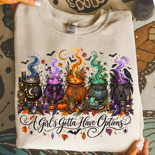 Five cauldrons with various potions and Halloween decorations above the text "A Girl's Gotta Have Options."