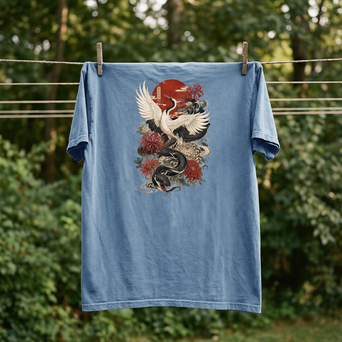 Blue t-shirt with a Japanese-style dragon and crane design, hung on a clothesline.