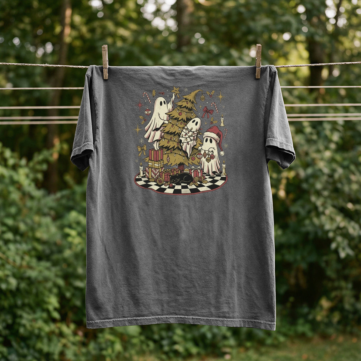 T-shirt with ghosts decorating a Christmas tree with gifts and a cat.