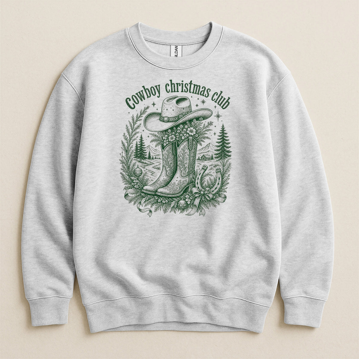Grey sweatshirt with green "Cowboy Christmas Club" text and festive cowboy graphic.