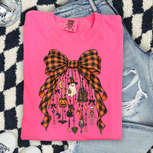 Pink t-shirt with orange and black plaid bow and Halloween charms.