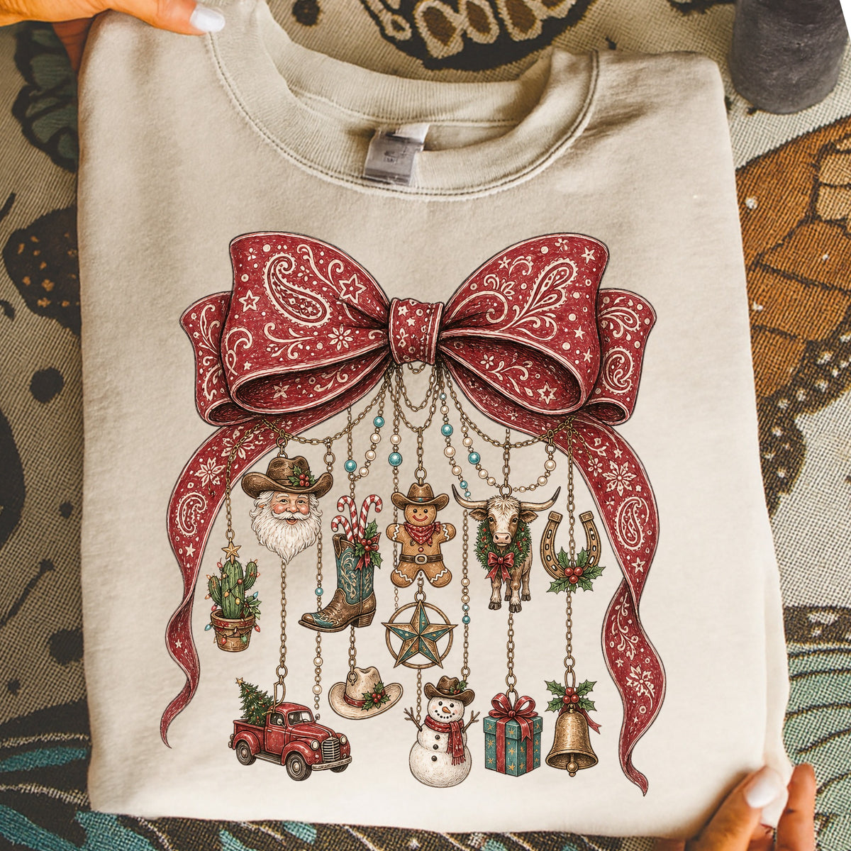 Light tan sweatshirt with a large red bandana print bow and dangling Christmas ornaments.