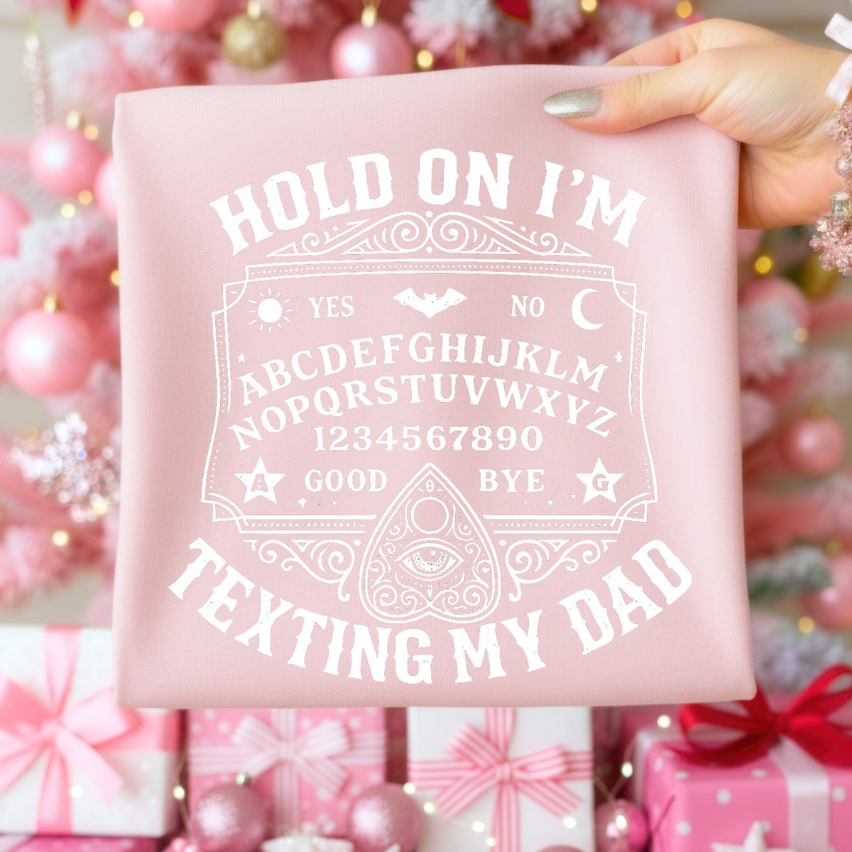 Pink t-shirt with "Hold on I'm texting my dad" in white Ouija board design.