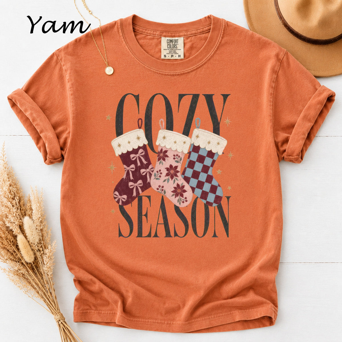 Orange t-shirt with "Cozy Season" text and three decorative Christmas stockings.