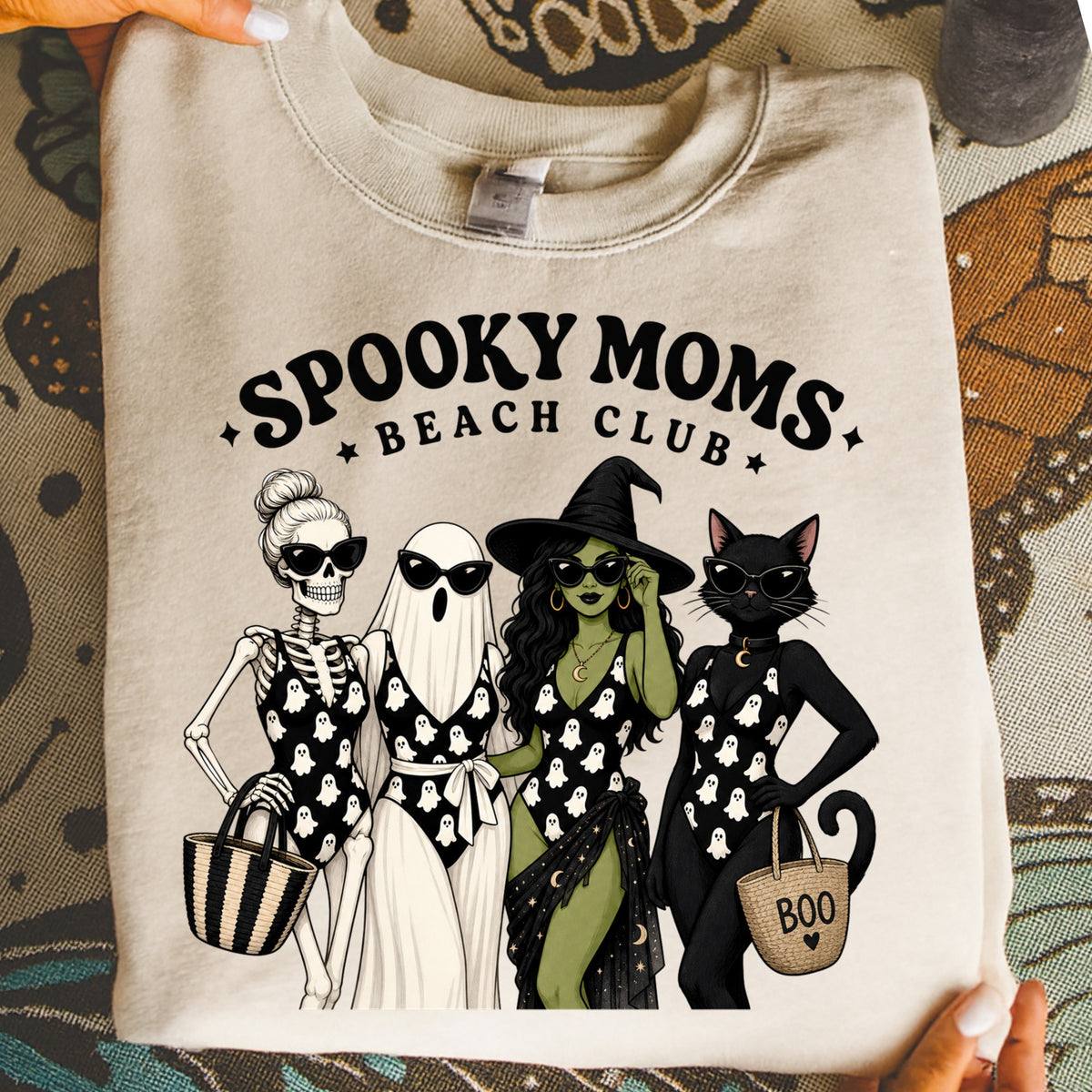 "Spooky Moms Beach Club" graphic with skeleton, ghost, witch, and cat wearing swimsuits.